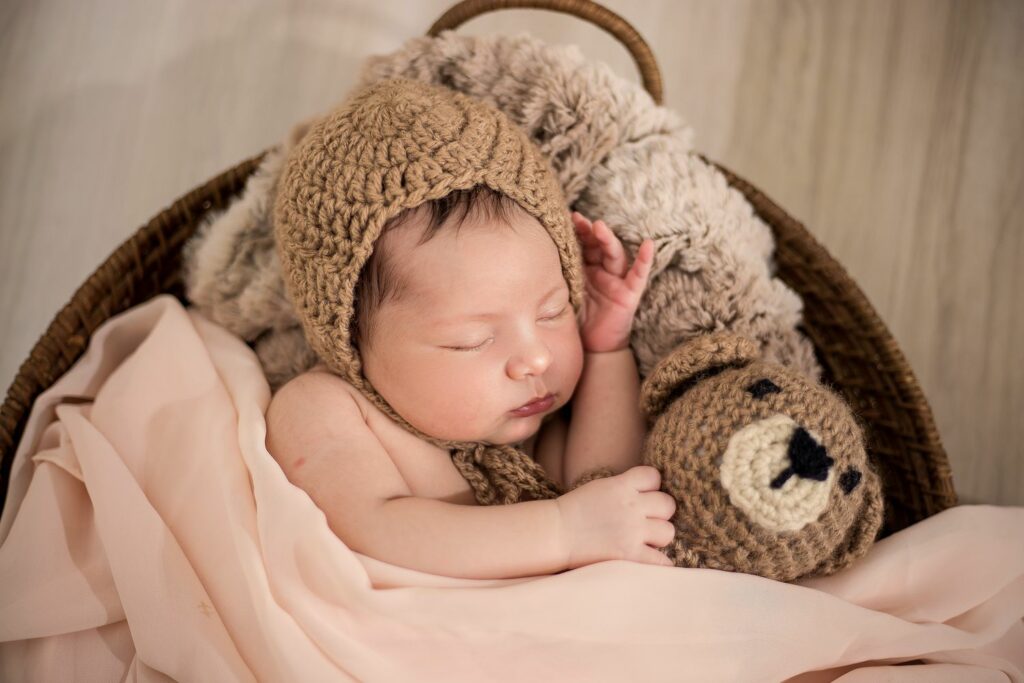süßes Baby in braunem Häkelmützchen mit Bärchen