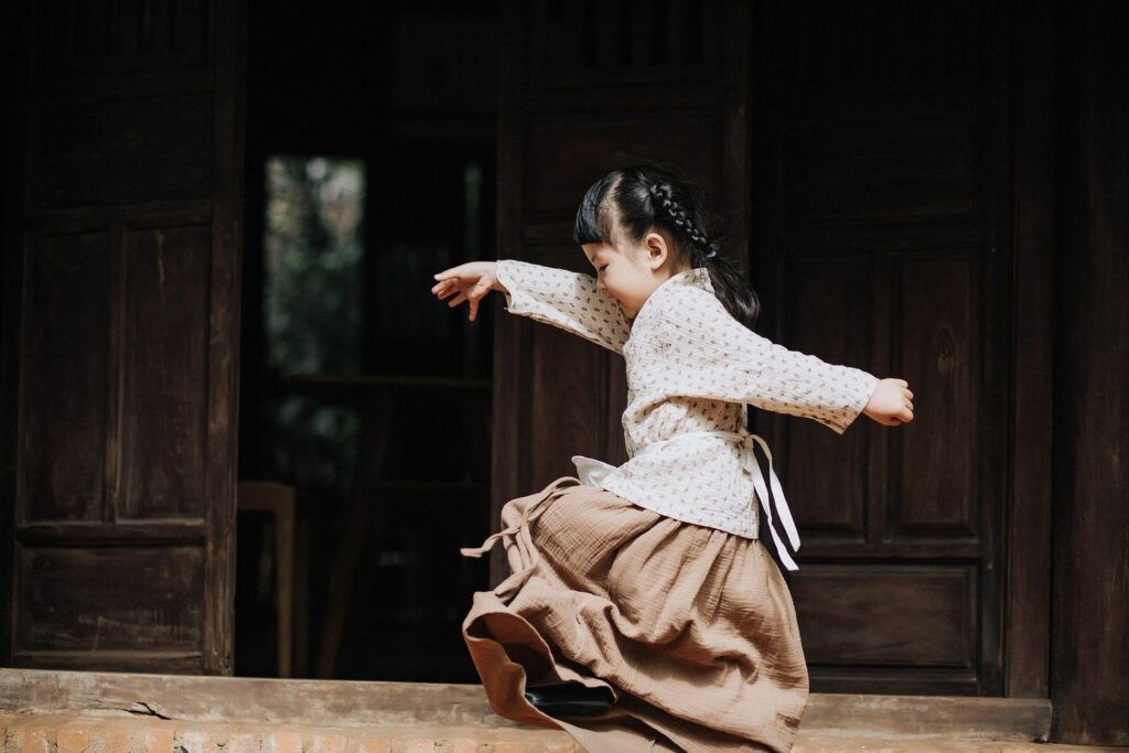 asiatisches Mädchen in japanischer Tracht mit langen Zöpfen, geht beschwingt