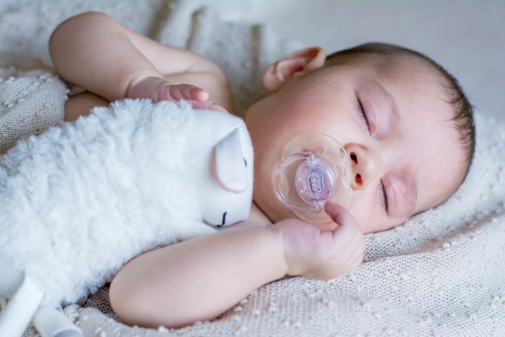 schlafendes Baby mit Kuscheltier Schäfchen