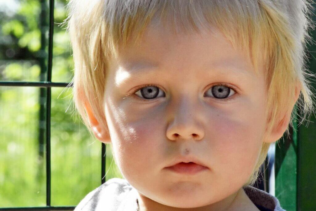 blondes Kind große blaue Augen schmutzige Nase